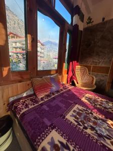 a bedroom with a bed with a view of a mountain at Snow View Guest House in Kasol