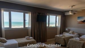 a hotel room with two beds and a view of the ocean at Hotel AATRAC in Mar del Plata