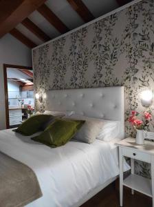 una camera da letto con un grande letto bianco con un muro di La Casa del Camino a Santiago de Compostela