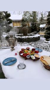 a table with plates of food on top at Qafqaz Fountain Villa in Gabala
