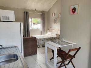 een keuken met een wastafel en een tafel in een kamer bij Residencial Barceloneta in Florianópolis