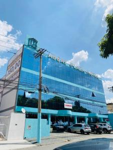 a blue building with cars parked in front of it at Assay Plaza Hotel in Hortolândia
