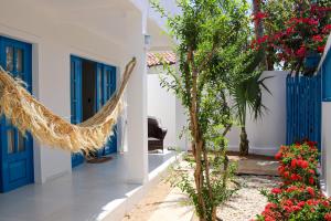 a house with a hammock in a courtyard with flowers at Vila Marinella in Jericoacoara +9 photos