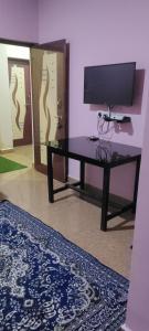 a living room with a tv and a table at Hotel Shonarbangla in Calangute