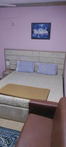 ein Bett mit zwei blauen Kissen darüber in der Unterkunft Hotel Shonarbangla in Calangute