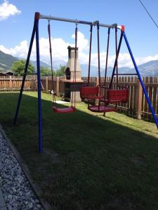a playground with two swings in a yard at Apart bianca Zillertal in Kaltenbach