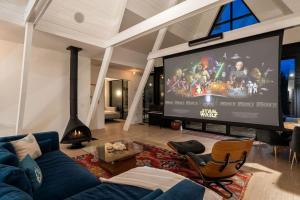 a living room with a blue couch and a large screen at Mountain Top Modern Lakefront in Sunset Magazine in Big Bear Lake