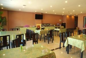 a dining room with tables and chairs in a restaurant at Wo Er Si Hotel in Fusong