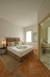 1 dormitorio blanco con 1 cama grande y baño en Liberty Dream, fascino a Vicenza, en Vicenza