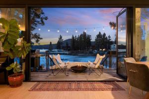 a patio with white chairs and a fire pit at Mountain Top Modern Lakefront in Sunset Magazine in Big Bear Lake