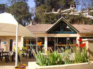 un restaurante con mesas y flores delante de él en Bungalow charmant à Saint-Jean-du-Gard avec piscine partagée, en Saint-Jean-du-Gard 2 fotos más