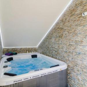 Cette chambre dispose d'un bain à remous et d'un mur en briques. dans l'établissement 6 bedrooms villa with sea view private pool and jacuzzi at Dubravka Konavle, à Dubravka