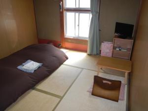 京都赤塔旅馆的一间卧室，里面有一张床、一把椅子和一扇窗户