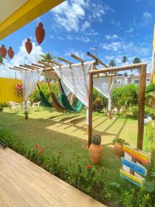a playground with a hammock and a swing set at Pousada O Sol De Maragogi in Maragogi