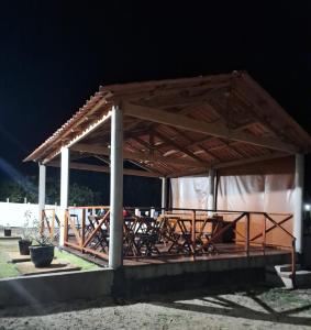 a pavilion with tables and chairs under it at night at Essência de Atins in Atins