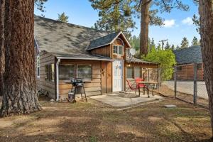 eine kleine Hütte mit Grill und Tisch in der Unterkunft Bear Sky Cabin in Big Bear City