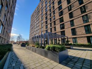 a large brick building with plants in front of it at Trafford Suite Modern 1 bed with cinema room in Manchester