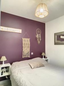 - une chambre avec un mur violet et un lit dans l'établissement Vue mer, piscine, free parking, à Théoule-sur-Mer
