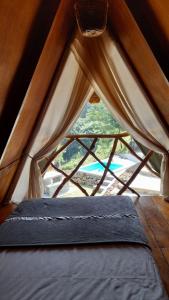łóżko w namiocie z dużym oknem w obiekcie Dream Ville w mieście Ella