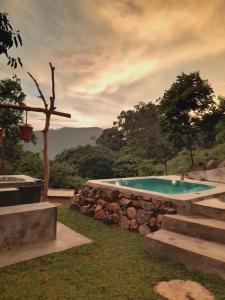 una piscina con una pared de piedra y un árbol en Dream Ville en Ella