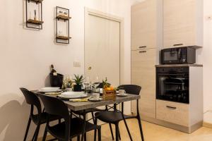 a dining room with a table with chairs and a microwave at Figline Valdarno , Monolocale nel centro a 2 passi dalla stazione ! in Figline Valdarno +15 photos