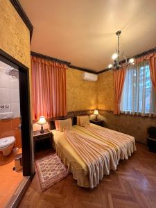 a bedroom with a large bed and a bathroom at Guesthouse Petra in Veliko Tŭrnovo