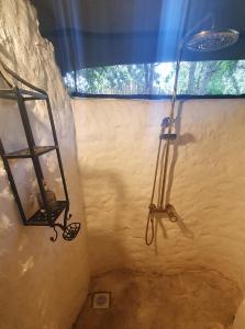 a bathroom with a shower with a light on the wall at Family Tent - Dolly Farm & River Camp in Usa River