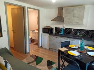 a kitchen with a table and a dining room at Les Apparts du Vignal de Cheyrac in Polignac