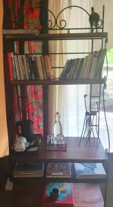 a book shelf with books and a cat sitting on it at Family Tent - Dolly Farm & River Camp in Usa River