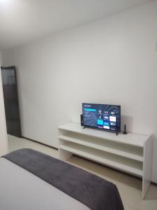 a living room with a tv on a white cabinet at Studio In - Apt° 205 com Garagem in Brasilia