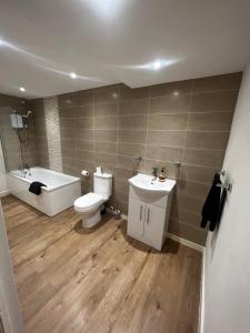 a bathroom with a toilet and a tub and a sink at No 2 at Mannering, Large 1 bed near Lark Lane in Liverpool