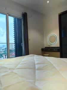 a bedroom with a large white bed and a large window at Quill Residences Suites Kuala Lumpur in Kuala Lumpur