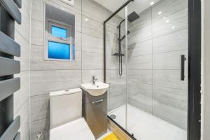 a bathroom with a shower and a toilet and a sink at Two Bed Home In the Heart of Egham in Egham