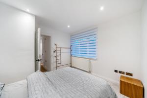 Habitación blanca con cama y ventana en Two Bed Home In the Heart of Egham, en Egham