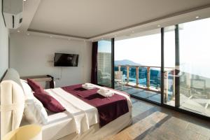 a bedroom with a large bed and a balcony at Villa Panorama Kalkan Jilda Livya in Kalkan +69 photos
