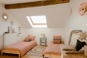 two beds in a room with a window at Logement entier ou à partager dans maison familiale à Rueil Malmaison, proche de Paris La Défense in Rueil-Malmaison