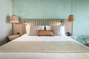 Nattivo Collection Hotel في سان أندريس: غرفة نوم بسرير ابيض كبير ومصباحين