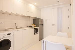 a white kitchen with a sink and a dishwasher at Marjan Island - Studio Open Sea View in Ras al Khaimah +12 photos