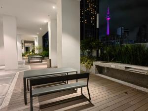 a balcony with benches and a view of the city at night at Quill Residences Suites Kuala Lumpur in Kuala Lumpur