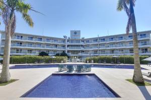 a hotel with a pool in front of a building at Hotel Porto Sol Beach in Florianópolis