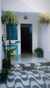 a room with a table and potted plants on the floor at Hostel Aconchego do Arraial in Arraial d'Ajuda