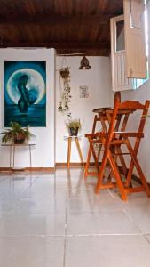 um quarto com uma cadeira e um quadro na parede em Hostel Aconchego do Arraial em Arraial d'Ajuda