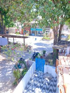 a garden with a blue fence and a tree at Hostel Aconchego do Arraial in Arraial d'Ajuda
