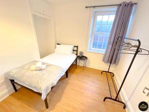 a small bedroom with a bed and a window at Modern 2 Bed Apartment - FREE Parking - Contractors in Morpeth