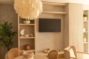 sala de estar con TV, mesa y sillas en Nattivo Collection Hotel, en San Andrés