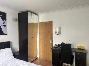 a bedroom with a bed and a desk and a door at 3 Luxury En-suite Bedrooms in Cardiff