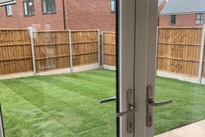 an open door to a yard with a fence at Walsall New Large House with Garden in Pelsall