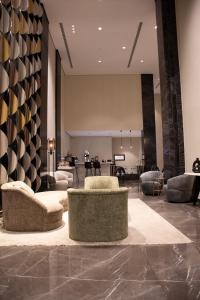 a lobby with couches and chairs and a piano at جراند ريجس للشقق الفندقية in Riyadh