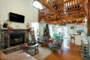 un salon avec une cheminée et un arbre de Noël dans l'établissement Azure Woods Grill Fireplace GameArea CommunityPool, à Townsend
