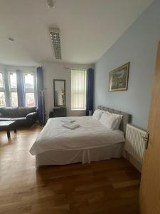 1 dormitorio con 1 cama blanca y sala de estar en 3 Luxury En-suite Bedrooms, en Cardiff